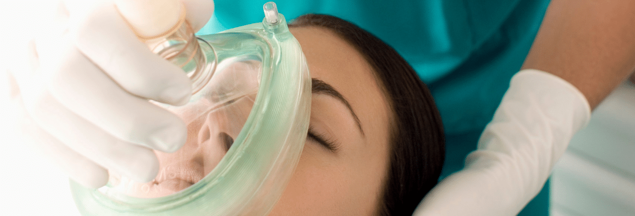 Doctor placing anaesthesia mask over patient